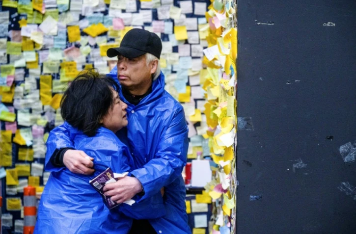 Cho Mi-eun (à gauche) et son mari Lee Jong-chul, dont le fils a péri dans la bousculade de Halloween, devant le mémorial installé sur le lieu de la tragédie dans le quartier d'Itaewon à Séoul, le 5 avril 2023
