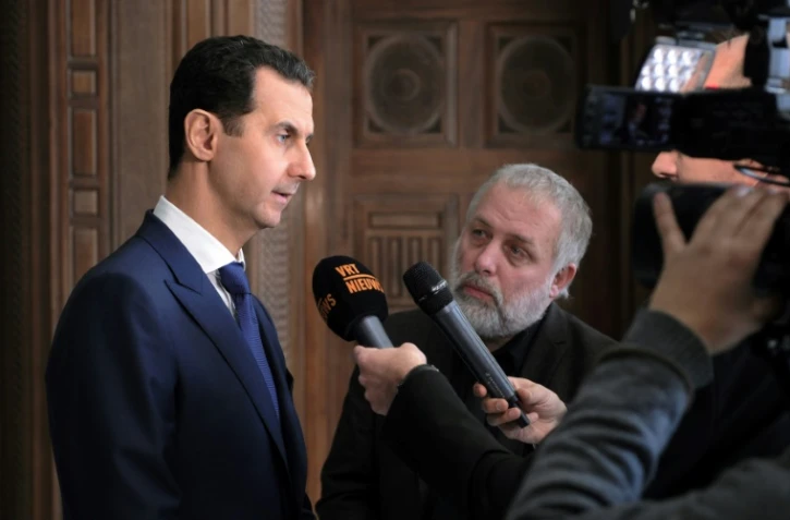Le président syrien Bachar al-Assad (g) lors d'une interview accordée à des journalistes belges, le 7 février 2017 à Damas