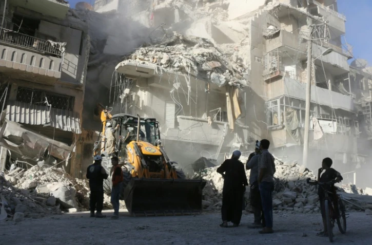Déblaiement des décombres d'un immeuble détruit par les bombardements du régime syrien le 24 septembre 2016 à Alep