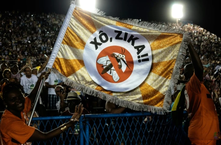 Des employés de la ville de Rio déploient un drapeau portant l'inscription "Zika, dehors !!", le 9 février 2016 à Rio de Janeiro