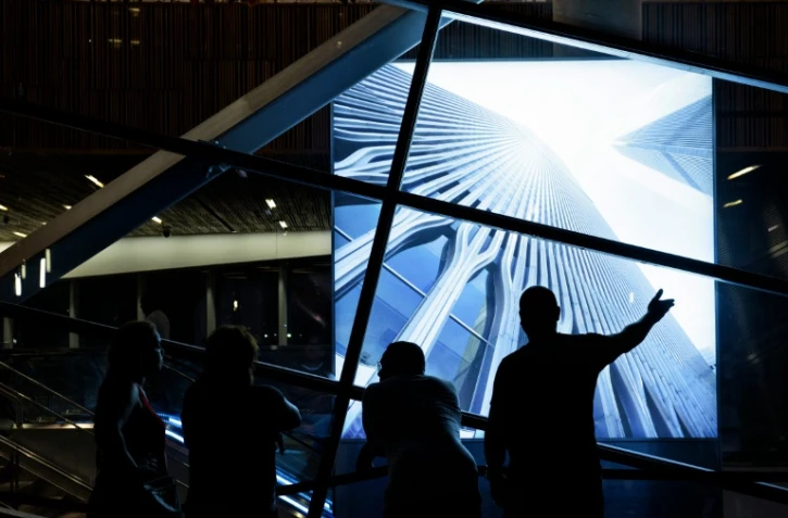 Des gens regardent à New York le 10 septembre 2016 une photo des tours jumelles du World Trade Center détruites le 11 septembre 2001