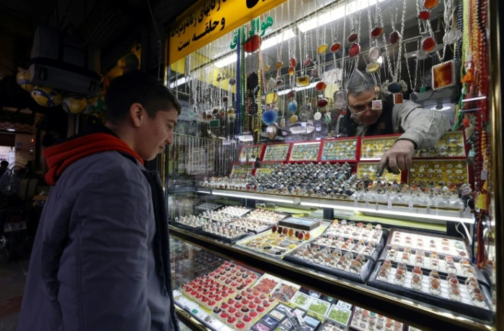 Un Iranien regarde des bagues de pierres précieuses dans une boutique d'un bazar au sud de Téhéran, le 8 janvier 2024