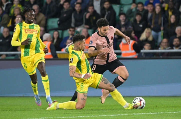 Le Brésilien Douglas Augusto (C) buteur pour Nantes contre le Paris SG (1-1), aux prises avec le Parisien Gonçalo Ramos (d), lors de la 29e journée de Ligue 1, le 22 avril 2025 à la Beaujoire