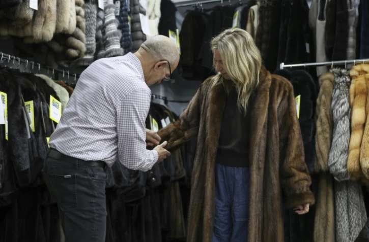 Le propriétaire du magasin de fourrures Madison Avenue Furs à New York, Larry Cowit, avec une cliente, le 10 mars 2026