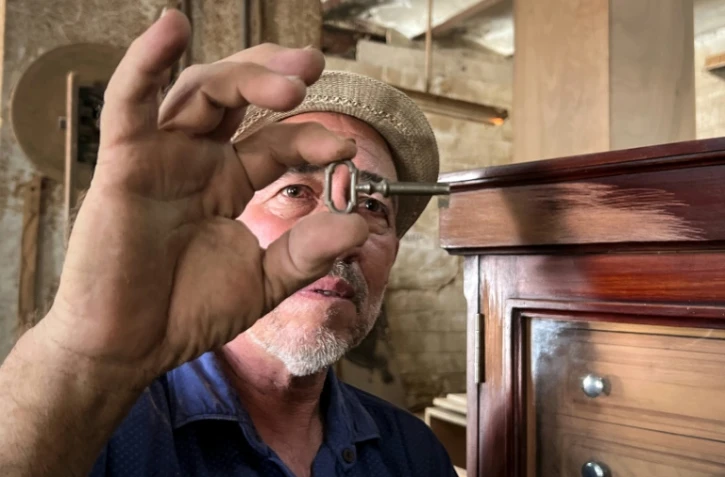 L'artisan René Reyes vérifie la clé d'une cave à cigares dans son atelier de La Havane, le 5 septembre 2023 à Cuba