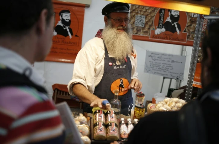 Un exposant allemand montre un bocal d'ail au Terra Madre Salone del Gusto du mouvement Slow Food Ă Turin le 22 septembre 2016