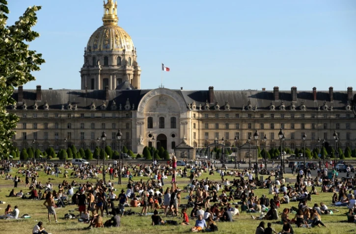 Des personnes prennent le soleil dans les jardins de l'Esplanade des Invalides, le 28 mai 2020 Ă Paris