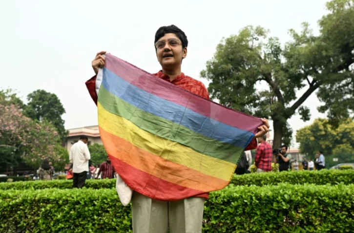 Un militant tient un drapeau  arc-en-ciel lors d'un rassemblement devant la Cour suprême de l'Inde le 17 octobre 2023 à New Delhi