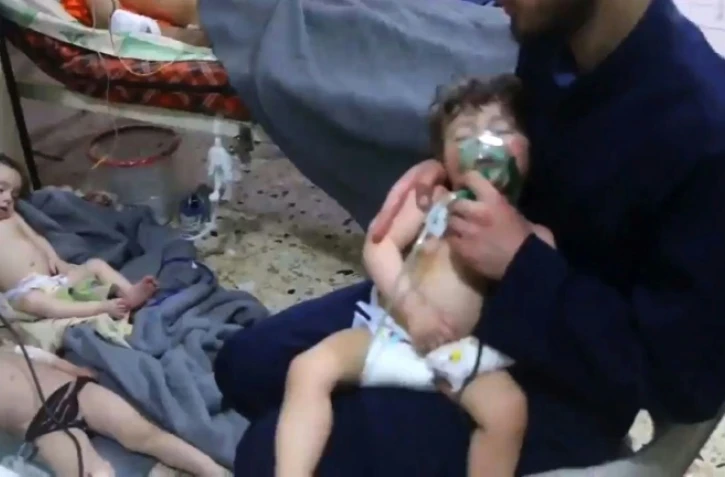 Une image prise sur une vidéo de la Défense civile syrienne montre des volontaires aidant des enfants victimes d'une attaque chimique présumée à Douma, le 8 avril 2018