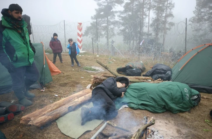 Des migrants campent à la frontière entre la Pologne et le Bélarus, dans la région de Grodno, le 11 novembre 2021