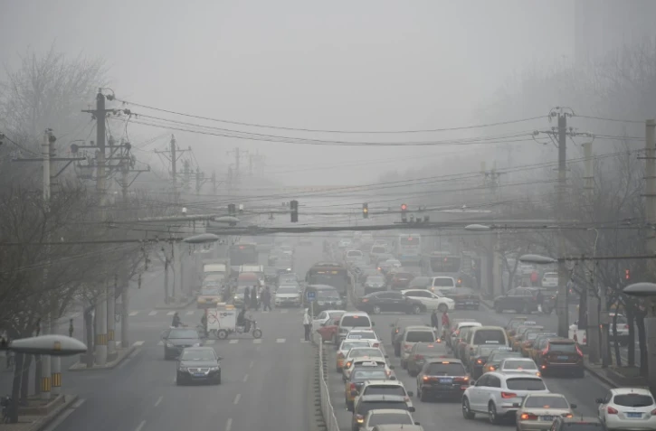 Des files de voiture prises dans un brouillard de pollution à Pékin, le 26 décembre 2015