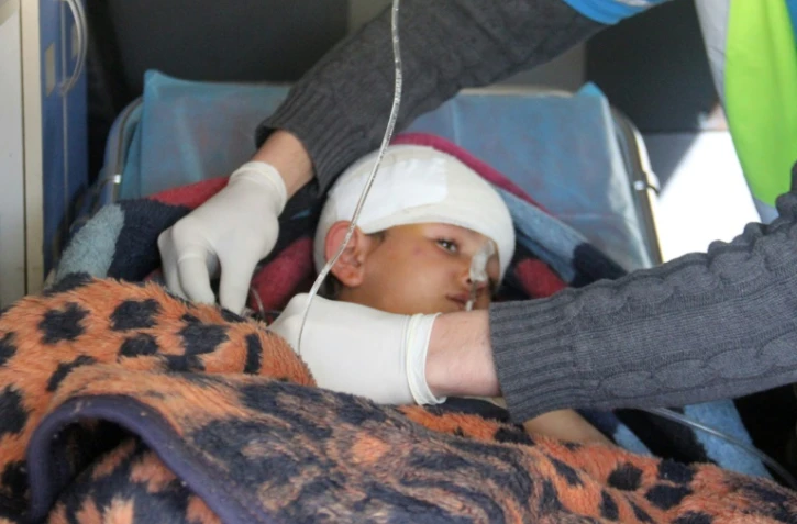 Un enfant syrien, Abdel Basset Al-Satuf (C) dans une ambulance à Al-Hbeit, dans la province d'Idleb le 17 février 2017 