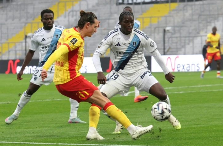 Le Lensois Florian Thauvin (g) aux prises avec le défenseur du Paris FC Nhoa Sangui lors de la victoire des Sang et Or 2-1, le 19 octobre 2025 à Lens