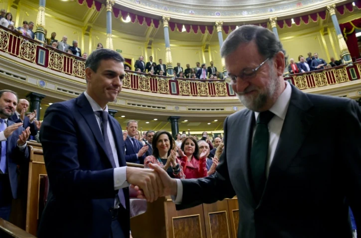 Mariano Rajoy serre la main de Pedro Sanchez (g) après avoir été renversé par le Parlement, le 1er juin 2018 à Madrid