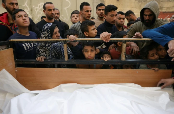 Des Palestiniens se rassemblent autour de corps couverts avant leur  enterrement, à Jabalia dans le nord de la bande de Gaza, le 16 avril 2025

