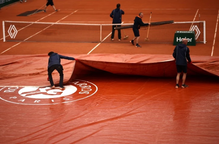 Des officiels retirent la bâche sur le court Simonne-Mathieu à Roland-Garros, le 30 mai 2024
