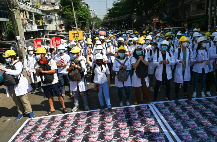 Des portraits barrés d'une croix rouge du général Min Aung Hlaing au sol lors d'une manifestation contre le coup d'Etat militaire, le 5 mars 2021 à Rangoun, en Birmanie