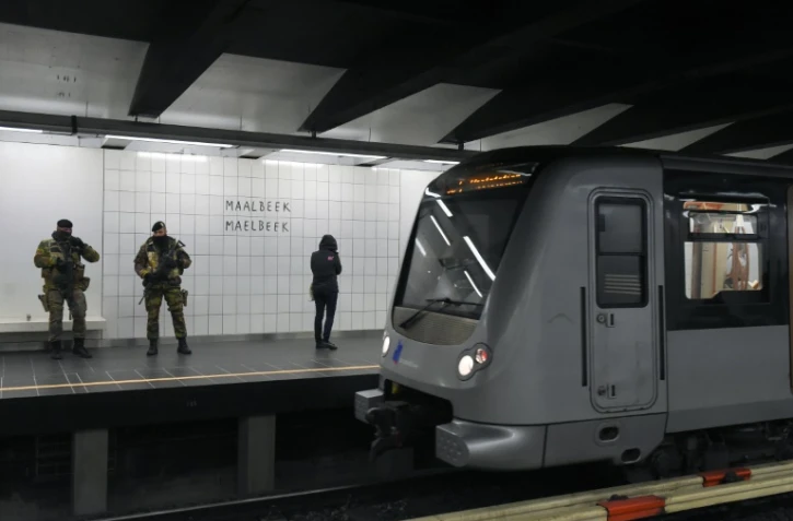 Des militaires belges montent la garde, le 25 avril 2016 à la station de métro Maelbeek à Bruxelles, à sa réouverture un mois et trois jours après les attentats jihadistes qui ont frappé la capitale belge, faisant 32 morts et des centaines de blessés