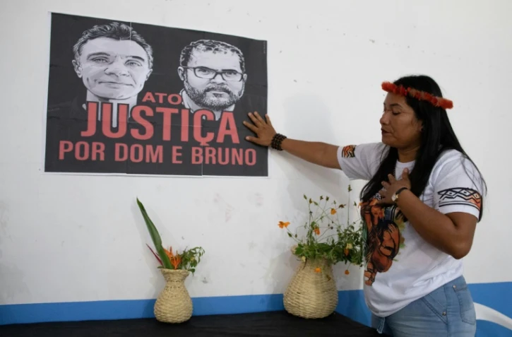 Une femme indigène touche une affiche réclamant justice pour l'expert indigène Bruno Pereira et le journaliste britannique Dom Phillips lors d'une cérémonie pour leur mort au siège de l'association de l'Union des peuples indigènes de la vallée de Javari (UNIVAJA), à Atalaia do Norte, dans l'État d'Amazonas, au Brésil, le 21 juin 2022