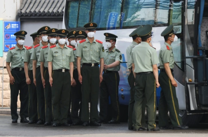 Des policiers chinois s'apprêtent à boucler les accès au marché Xinfadi de Pékin, le 13 juin 2020