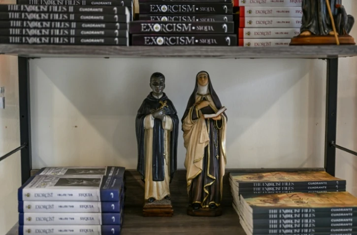 Des statuettes de saints sur une étagère de livres dans le Centre Saint-Michel pour la libération spirituelle et l'exorcisme, le 18 juillet 2026 à Manille