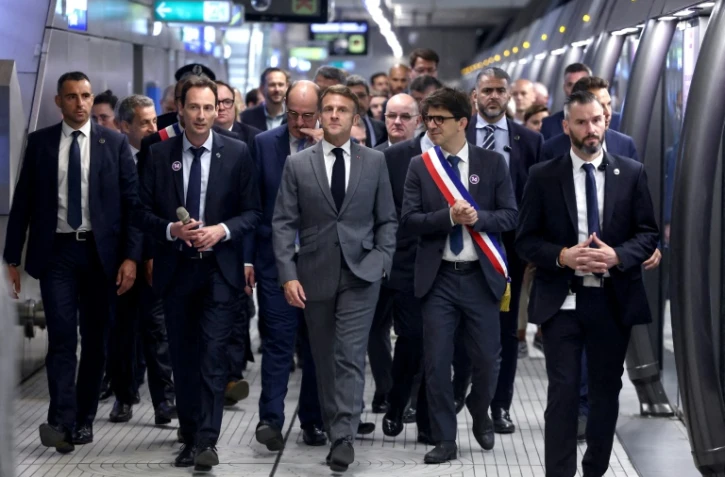 Emmanuel Macron (c) et des officiels sur le quai de la nouvelle station "Mairie de Saint-Ouen", sur la ligne 14 du métro parisien, le 24 juin 2024