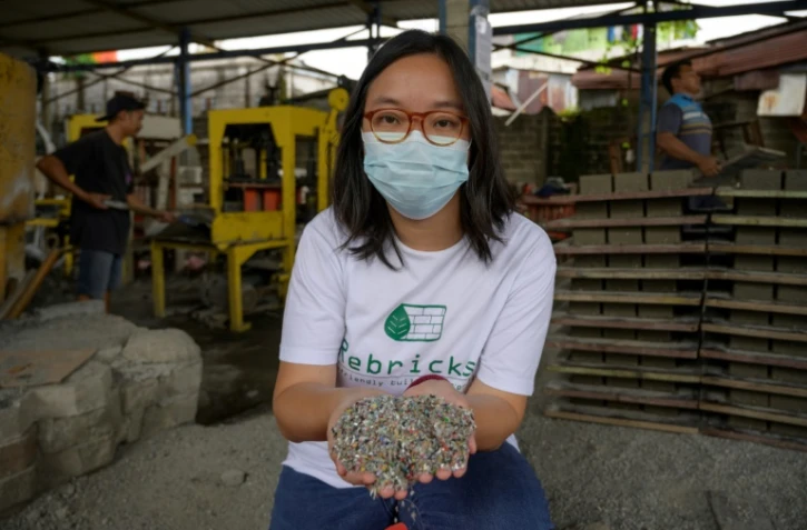 Novita Tan, cofondatrice de Rebrick, montre des déchets plastiques réduits en petits morceaux qui seront transformés en briques, le 7 avril 2021 à Jakarta, en Indonésie