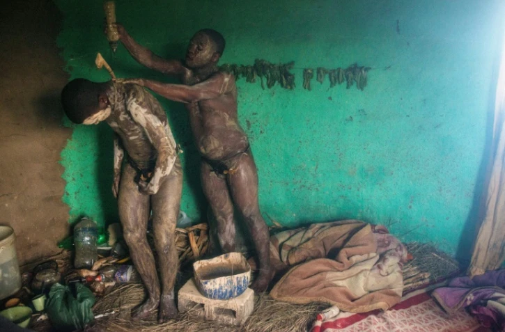 Deux jeunes hommes de l'ethnie sud-africaine xhosa, Fezikhaya Tselane (g), 20 ans, et Khanyisile Mapope, 18 ans, participent à un rite initiatique consistant notamment en une circoncision avec un simple couteau, le 13 juillet 2017 à Umtata
