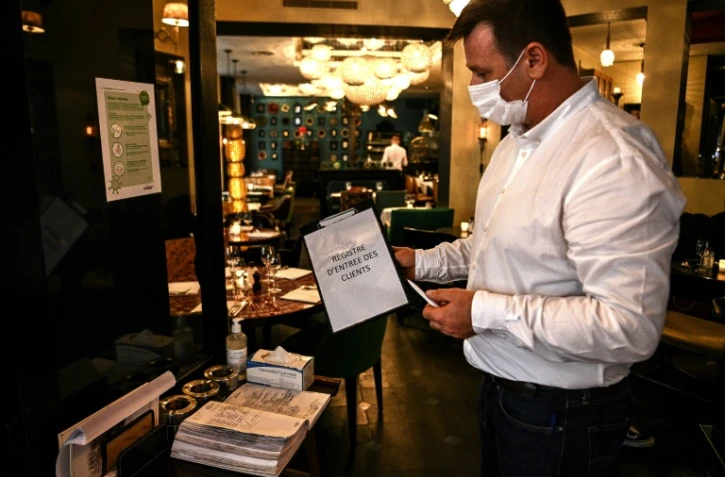 Les clients des restaurants devront laisser leur nom, leur numéro de téléphone et éventuellement leur adresse mail dans un "cahier de contact", comme ici à Paris le 5 octobre 2020.
Ils pourront ainsi être prévenus par l'Assurance maladie en cas de détection d'un cas de Covid-19 chez un consommateur venu dans l'établissement