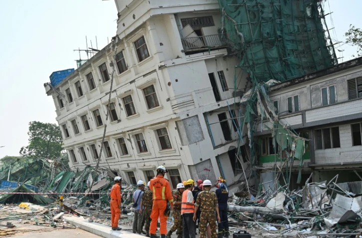Des équipes de secouristes chinois et bélarusses se coordonnent sur le site d'un bâtiment effondré à Mandalay le 2 avril 2025, cinq jours après le tremblement de terre qui a frappé le centre de la Birmanie