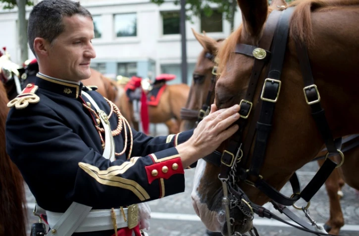 Un cavalier de la Garde républicaine prépare son cheval avant le défilé du 14 juillet 2014 sur les Champs-Elysées
