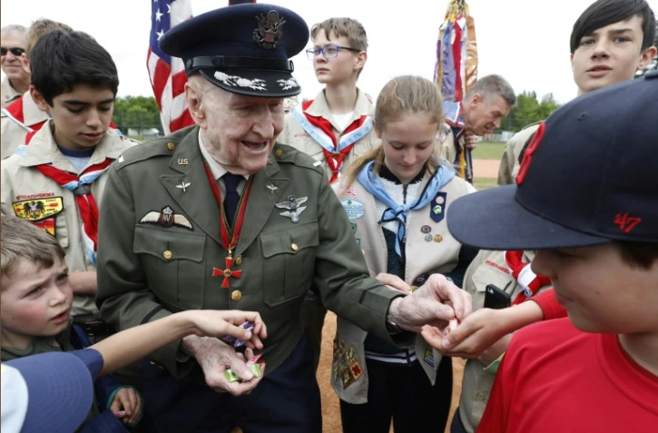 L'ancien pilote américain Gail Halvorsen - qui a participé au pont aérien de Berlin - distribue des bonbons aux membres d'une équipe berlinoise de baseball et à des scouts américains, lors d'une cérémonie sur l'ancien aéroport de Tempelhof, à Berlin le 11 mai 2019