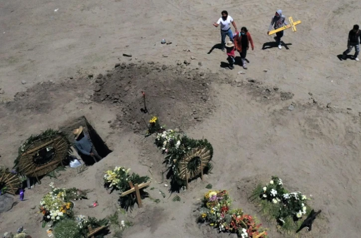Les proches d'une victime du Covid-19 portent une croix, dans un cimetière de Valle de Chalco (Mexique), le 4 juin 2020