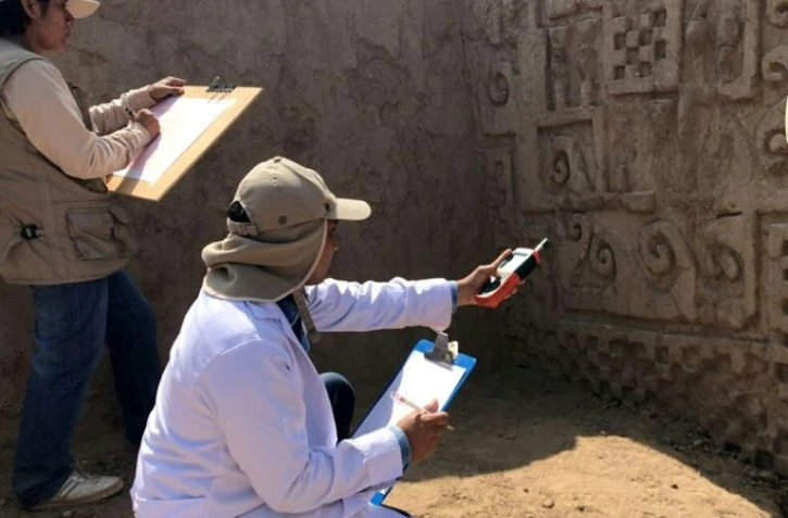 Des archéologues travaillent sur des peintures murales du site précolombien Chan Chan, le 16 juin 2018 au Pérou 
