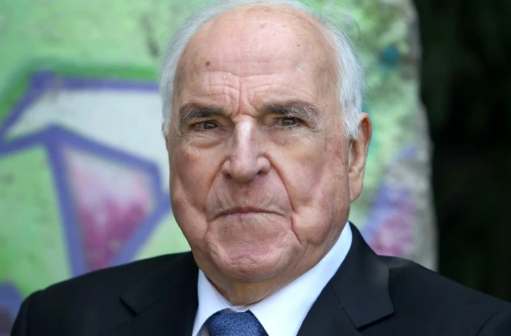 Helmut Kohl pose sur fond d'un élément du mur de Berlin dans son jardin à Oggersheim, en Allemagne, le 16 mai 2014