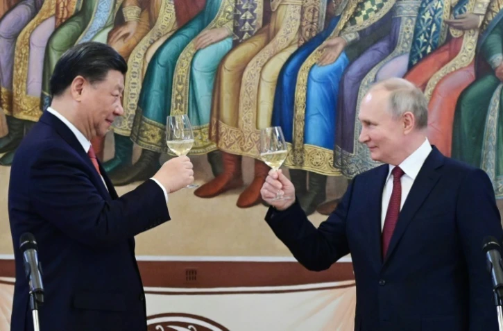 Le président chinois Xi Jinping (g) porte un toast avec son homologue russe Vladimir Poutine lors d'une réception au Kremlin, le 21 mars 2023 à Moscou