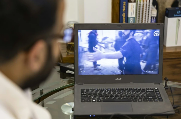 Le chirurgien orthopédique Mohammed al-Hanash regarde, le 21 décembre 2024, dans une clinique à Douma, une vidéo d'avril 2018 montrant Mouwafaq Nisrine, infirmier à l'époque, apportant les premiers soins d'urgence à une victime lors d'une attaque à Douma, en Syrie