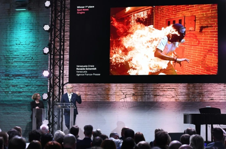 Ronaldo Schemidt s'exprime à Paris le 12 avril 2018 devant la photo qu'il a faite lors d'émeutes à Caracas le 3 mai 2017