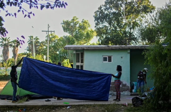 Des migrants haïtiens plient une tente, avant de quitter un camp de fortune à Ciudad Acuna, le 24 septembre 2021 au Mexique