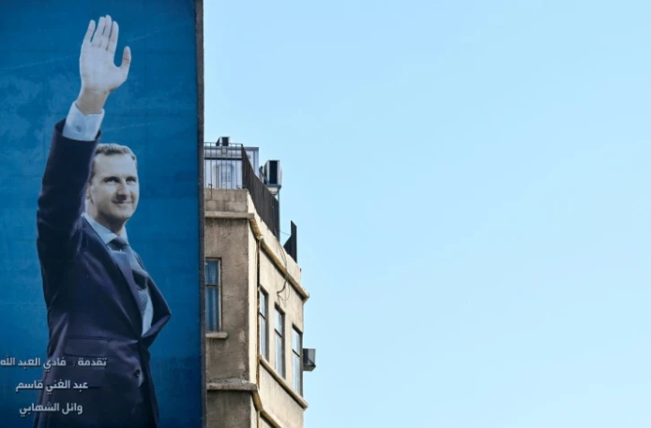 Une affiche géante du président syrien Bachar al-Assad dans une rue de Damas, le 2 décembre 2024