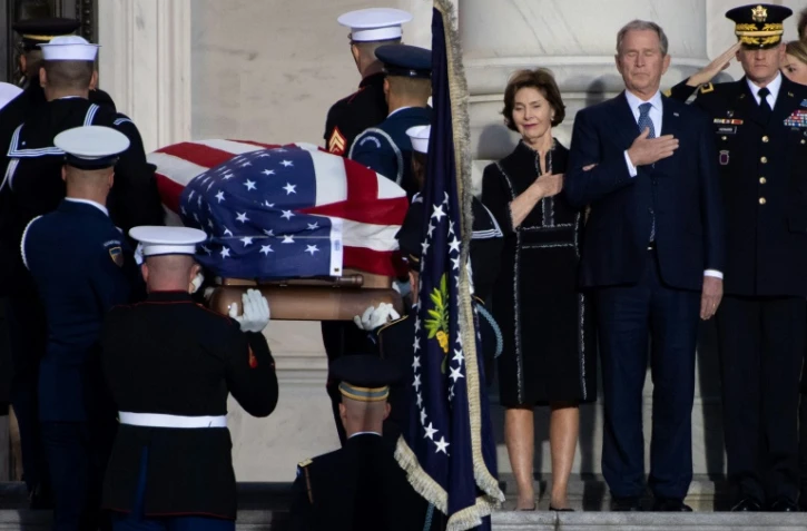 L'ancien président américain George W. Bush et son épouse Laura se recueille à l'arrivée du cercueil de George H. W. Bush au Capitole, le 3 décembre 2018