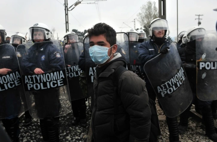 Un jeune migrant portant un masque à la frontière greco-macédonienne, près du village grec d'Idomeni le 27 mars 2016