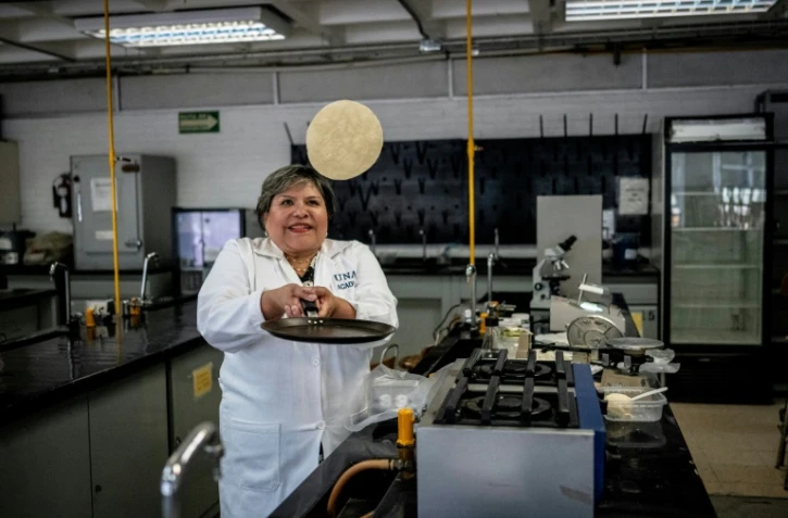 La docteure Raquel Gomez Pliego retourne une tortilla au laboratoire de micro-biologie de l'Université nationale autonome du Mexique (UNAM) à Mexico le 10 avril 2025