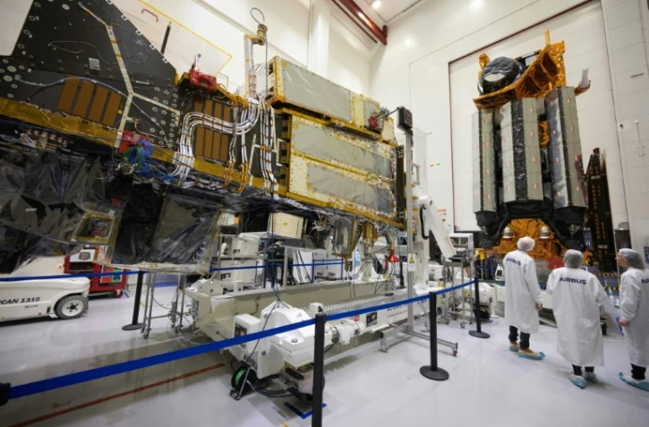 Des employés d'Airbus devant un satellite MetOp dans la "salle blanche" où l'on assemble les satellites à Toulouse, dans le sud-ouest de la France, le 10 novembre 2023