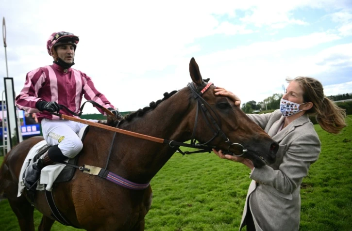 Le jockey Bertrand Lestrade, le cheval Docteur de Ballon, et l'entraineur Louisa Carberry, vainqueurs du Grand Steeple-Chase de Paris Ă l'hippodrome d'Auteuil, le 23 mai 2021