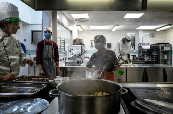 Des élèves écoutent les instructions de leur professeur lors d'une session de cuisine au lycée hôtelier de La Vidaude à Saint-Genis-Laval, le 11 juin 2020