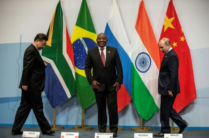 Le président chinois Xi Jinping (à gauche) et son homologue russe Vladimir Poutine (à droite) avec le président sud-africain Cyril Ramaphosa au sommet des BRICS le 26 juillet 2018 à Johannesburg.
