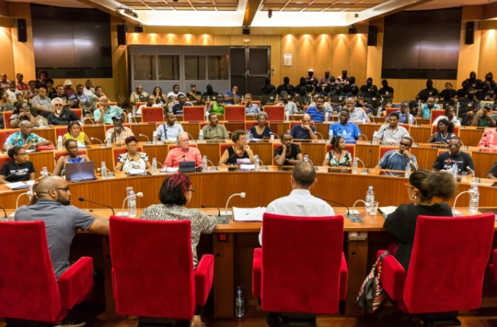 Des membres du collectif "Pou la Gwiyann dékolé" et des représentants élus des communautés territoriales discutent un projet d'accord pour mettre fin au conflit social, au siège de la CGT Guyane à Cayenne le 20 avril 2017 