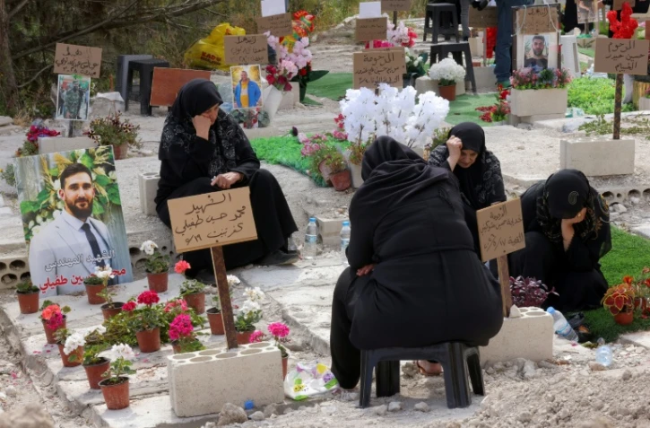 Des personnes déplacées se recueillent devant les tombes de leurs proches tués pendant le conflit avec Israël, le 27 mai 2026 près de Saïda, dans le sud du Liban