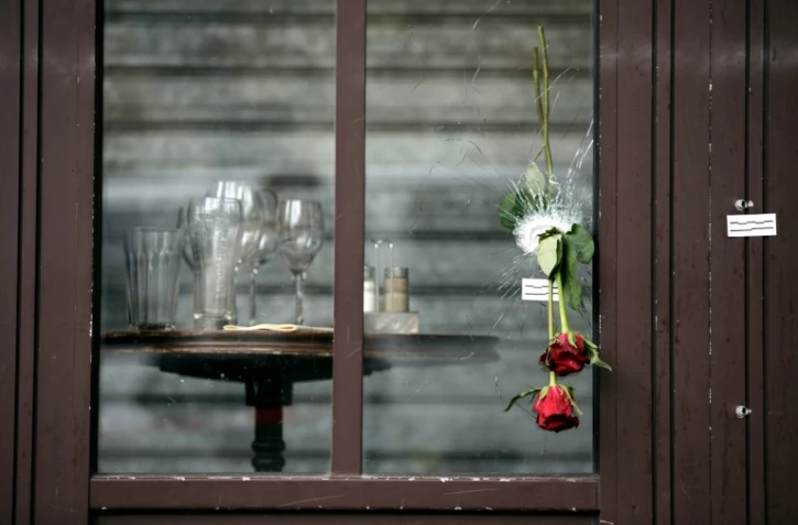 Des roses glissées dans les impacts de balle sur la vitrine de la "Bonne Bière" en hommage aux victimes, le 17 novembre 2015 à Paris